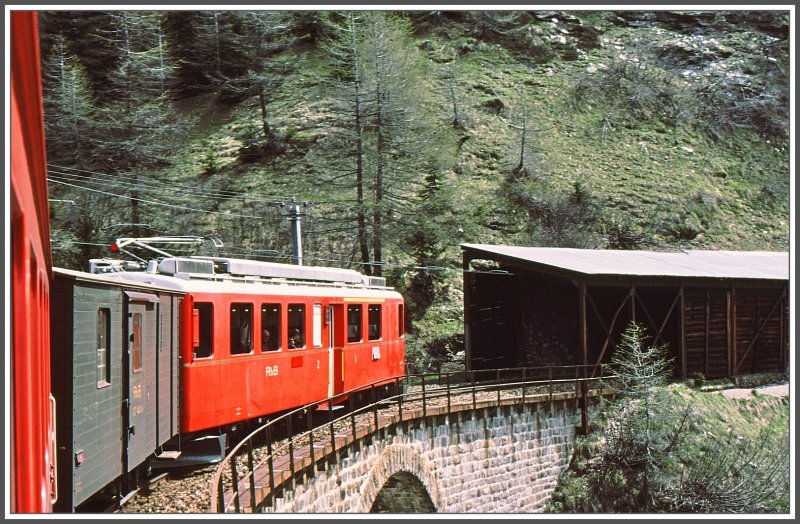 ABe 4/4 mit noch grnem zweiachsigen Gepckwagen auf Talfahrt oberhalb Cavaglia. (Archiv 06/83)
