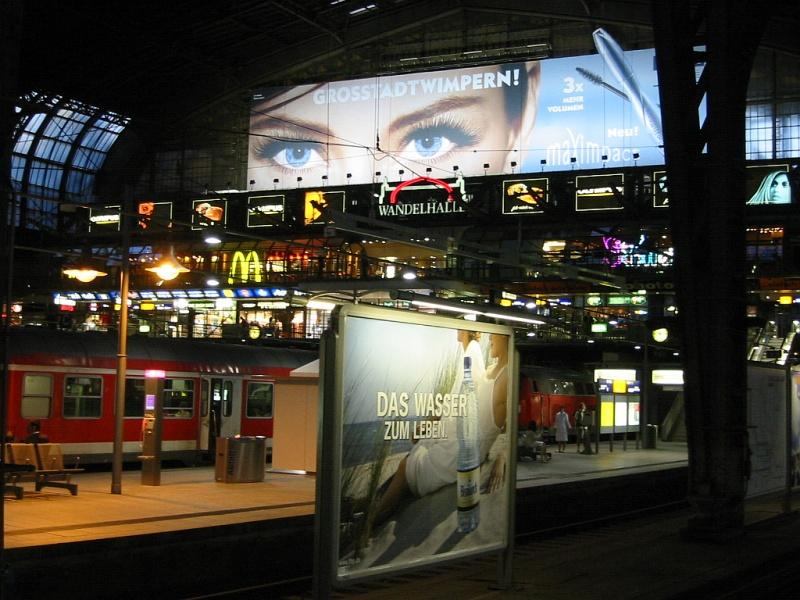 Abendstimmung in der Halle von Hamburg Hbf am 13.07.2005 so gegen 22:00 Uhr. Der Blick fllt auf die Wandelhalle im nrdlichen Ende der Bahnhofshalle, in der sich viele Geschfte und Gastronomie befinden..