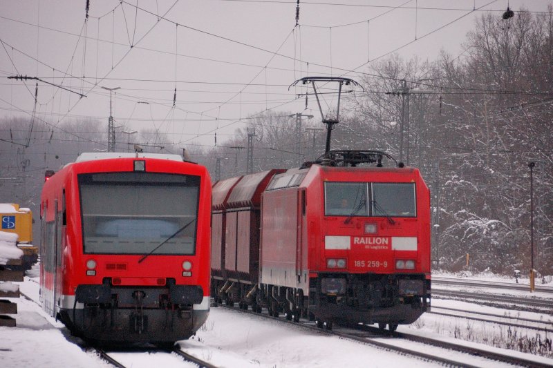 Abgestellt und noch nicht neu benummert lt sich dieses Regio-Shuttle von einem Kohlezug berholen. 185 259-9 zieht fast lautlos an der Br 650 vorbei... (Neuoffingen im Dez 2008).