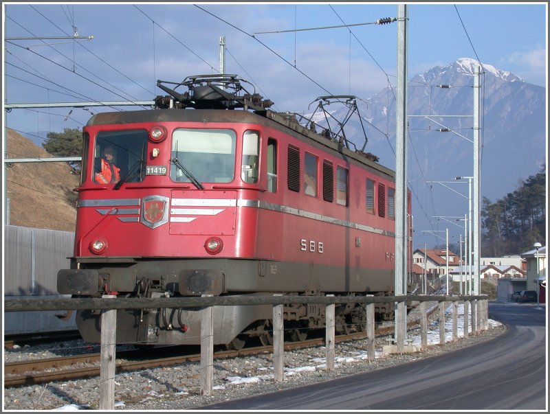 Ae 6/6 11419 kam ber das Dreischienengleis die ca. 6km von Chur nach Domat/Ems und wartet vor der Kulisse des Montalin auf die berfuhr aus den Ems Werken. (01.02.2007)