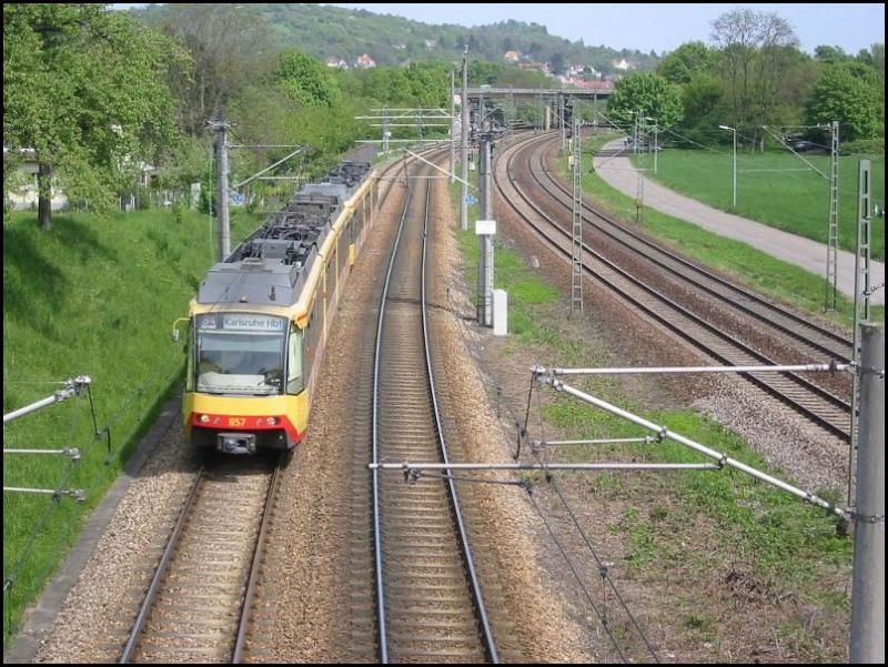 Am 04.05.2006 war diese Zweisystem-Stadtbahn mit dem Triebwagen 857 an der Spitze auf der Linie S4 zwischen den Karlsruher Stadtteilen Grtzingen und Durlach in Richtung Karlsruhe Hbf unterwegs. Die Aufnahme erfolgte von der Straenbrcke aus, die auf dem vorherigen Bild im Hintergrund zu sehen ist. Bei der Bahnstrecke, die rechts zu sehen ist, handelt es sich um die DB-Strecke zwischen Karlsruhe und Pforzheim. In diesem Bereich befindet sich auch die Systemwechselstelle von dem Gleichstrom des Karlsruher Straenbahnnetzes hin zu dem Wechselstrom des DB-Netzes.