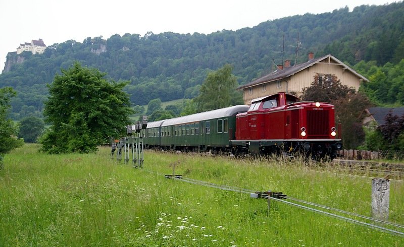 Am 06. Juni 2008 war die frisch Hauptuntersuchte, und mit neuem altroten Farbkleid versehene, V 100 2335 (ex DB 213 335) mit einem Leerreisezug auf der Donautalbahn (KBS 755) unterwegs. Das Bild entstand bei der Durchfahrt durch den Bahnhof Hausen i.T. Im Hintergrund ist die Burg Werrenwag zu erkennen.