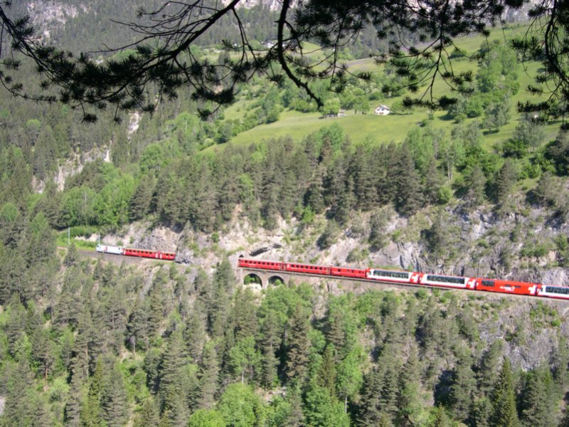 Am 11.06.2006 hat Ge 4/4 III 645 mit ihrem  Glacier  gerade den Landwasserviadukt hinter sich gelassen. Zwischen St. Moritz und Chur bzw. Reichenau verkehrt der Galcier vereint mit einem RegioExpress. Der Tunnel im Bild ist brigens der 27m lange Zalaint-Tunnel ber welchem sich die wohl bekannteste Fotostelle der Rhtischen Bahn befindet.