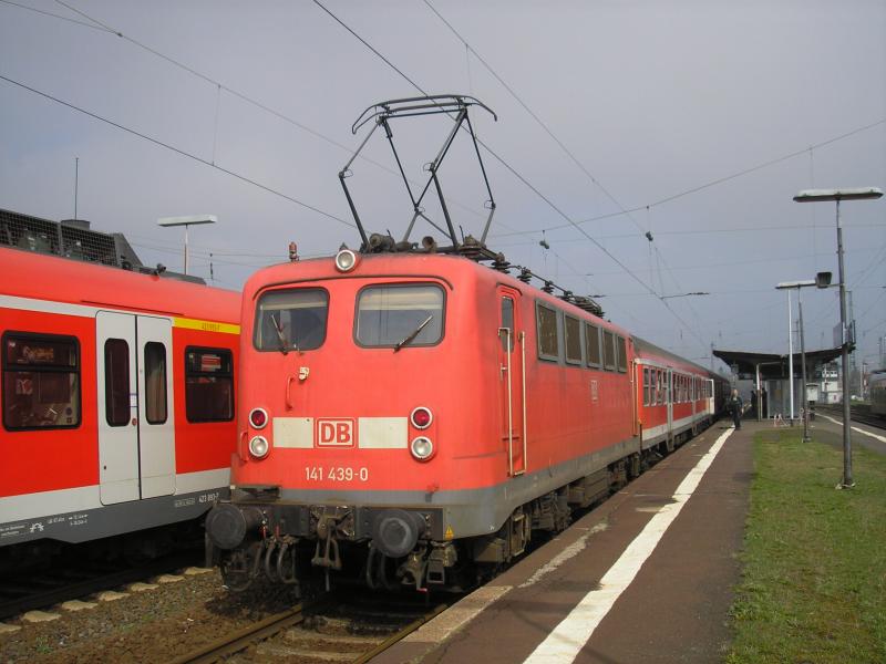 Am 13. Dezember 2003 fuhr die letzte 141 planm��ig eine RegionalBahn zwischen Gie�en und Friedberg; das vorliegende Bild entstand am 18. April 2006 in Friedberg. Fast zweieinhalb Jahre sind vergangen seit dem 13. Dezember, und die Baureihe 141 ist erneut in Friedberg zu sehen, als Ersatz f�r eine mit ihrem Nachfolger, der Baureihe 143, bespannten Zuge. 141 439, eine der letzten vier dieser Baureihe, am 18.4.06 also mit RB 25418 Friedberg - Gie�en vor der Abfahrt des Zuges.