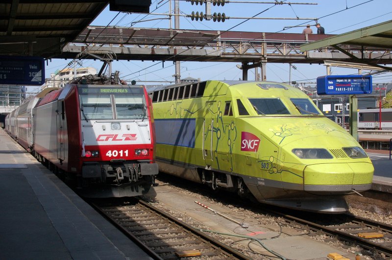 Am 13.04.2007 treffen sich die luxemburgische CFL 4011 der Baureihe 4000 und der TGV 503 im Bahnhof Luxemburg. Der gelbgrne TGV weist eine interessante Beklebung auf mit skizzierten Streckenabschnitten, die zu symbolisierten Menschen vervollstndigt wurden. Ganz schwach unterlegt wird das Gesamtkunstwerk von den Stdtenamen, die auf der TGV-Strecke liegen. Das Ziel dieses Zuges wird Paris-Est sein.