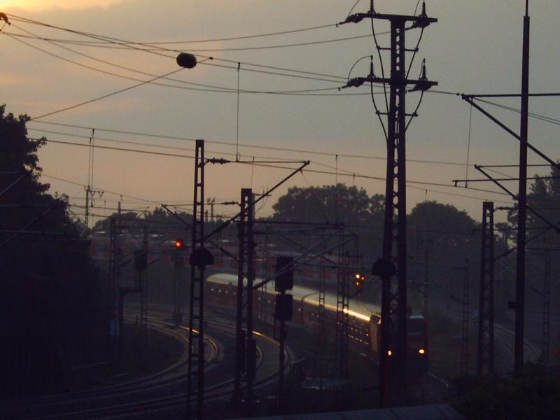 Am 18.06.06 durchquert die S6 auf dem Weg nach Essen ein Meer von Oberleitungsmasten und den krftigen Sommerregen kurz vorm Hansaring in Kln. Im Hintergrund schleicht die S 12 nach Dren.