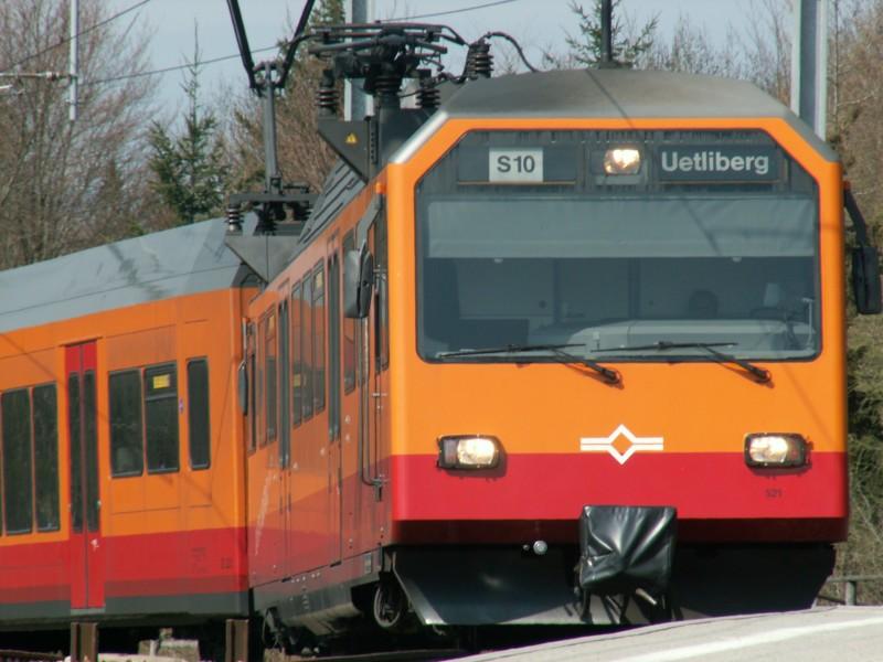 Am 21.April 2006 fhrt eine BDe 4/4 Komposition (zweimal BDe 4/4 mit Niederflur Zwischenwagen)der SZU auf dem 850 meter Hohen Uetliberg (der Hausberg von Zrich) als S 10 ein. Die Bahn besteigt innerhalb von 20 Minuten Fahrzeit ab Zrich HB ohne Zahnrad die Strecke.
Die Triebwagen stammen vom Hause Siemens und der Niederflur-Zwischenwagen von Stadler.