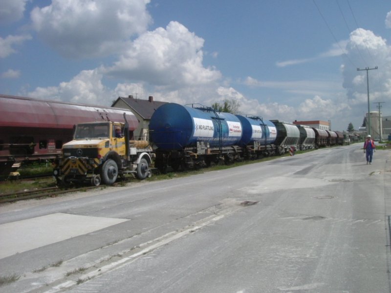 Am 25.05.2005 bringt der Zweiwege Unimog der Firma AKW die beladenen Wagen zur bergabestelle. Links wartet die bergabe schon! (Strecke Amberg-Schnaittenbach)