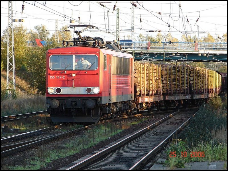 Am 25.10.06 zog die BR 155 147-2 im letzten Sonnenlicht ihren mit  Stammholz beladenen Zug in den Seehafen Rostock.