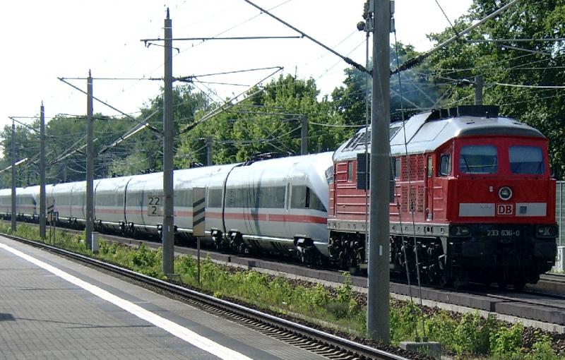 Am 28.05.2004 blieb dieser ICE auf der HGV Hannover - Berlin bei km 122,6 in Hhe Haltepunkt Dallgow-Dberitz wegen Stromabnehmerschaden mehrere Stunden liegen. Wenige Wochen zuvor war das auch schon in Berlin passiert. Die Fahrgste blieben wieder eingesperrt. Hier schleppt ihn die 233636 in Richtung Berlin ab. Die Bahn hatte Glck im Unglck, denn dieser Abschnitt ist viergleisig. So konnten alle Zge aus Richtung Hannover ber die Stammstrecke umgeleitet werden. Das Chaos war dennoch perfekt. Zum Verstndnis: Die Strecke war schon immer 4gleisig, hatte aber keine unterschiedliche Kilometrierung. Mit Inbetriebnahme der HGV wurde fr die Stammstrecke (Regionalverkehr) die alte Kilometrierung beibehalten, whrend sie fr die HGV um 100 erhht wurde. Die auf dem Bild sichtbare Tafel 22,2 bezieht sich also auf die Stammstrecke.