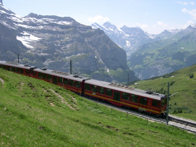 Am 28.06.2005 fhrt dieser Zug der Jungfraubahn zwischen Eigergletscher und Kleiner Scheidegg. In Krze wird er seine Ladung Japaner an der Kleinen Scheidegg ausladen. Wir blicken hier in das Lauterbrunnental. Am gegenberliegenden Berghang liegt Mrren.