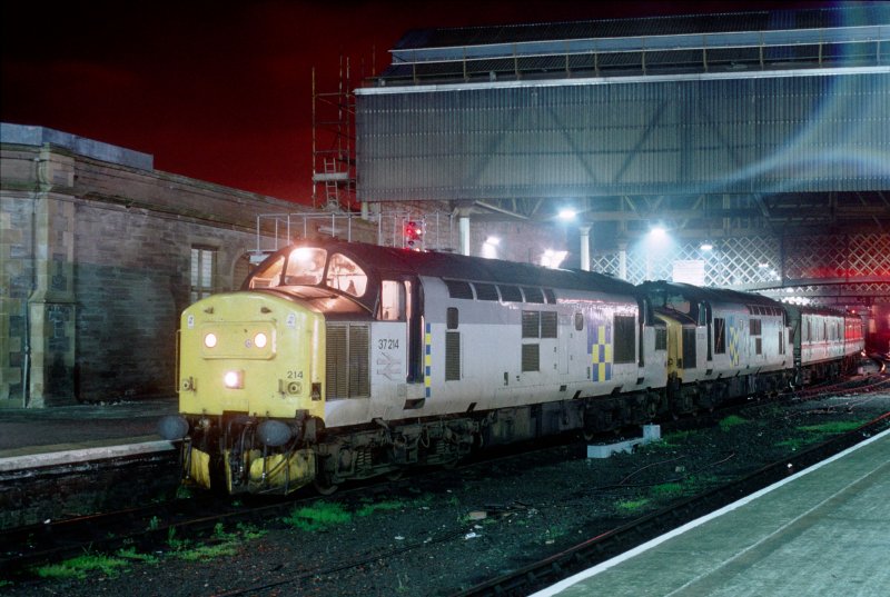 Am 7. Mai 1993 warten 37214 und eine weitere class 37 in Perth auf die Weiterfahrt mit dem Nachtzug von Inverness nach London Euston. Zwischen 1992 und 1995 waren die Nachtzuegen von Aberdeen und Inverness nach London mit zwei class 37s bespannt, da sie aus 12 Wagons bestanden. Heutzutage reicht eine class 67 und sieben Wagons.