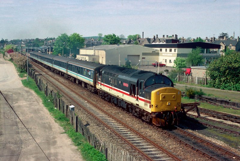 Am 8. Mai 1993 hat 37404 mit einem Inverness-Aberdeen Regionalzug soeben Elgin verlassen. Im Winter 1992/93 gab es noch zwei lokbspannte Zugpaare auf dieser Strecke, wegen eines Mangels an Triebwagons.