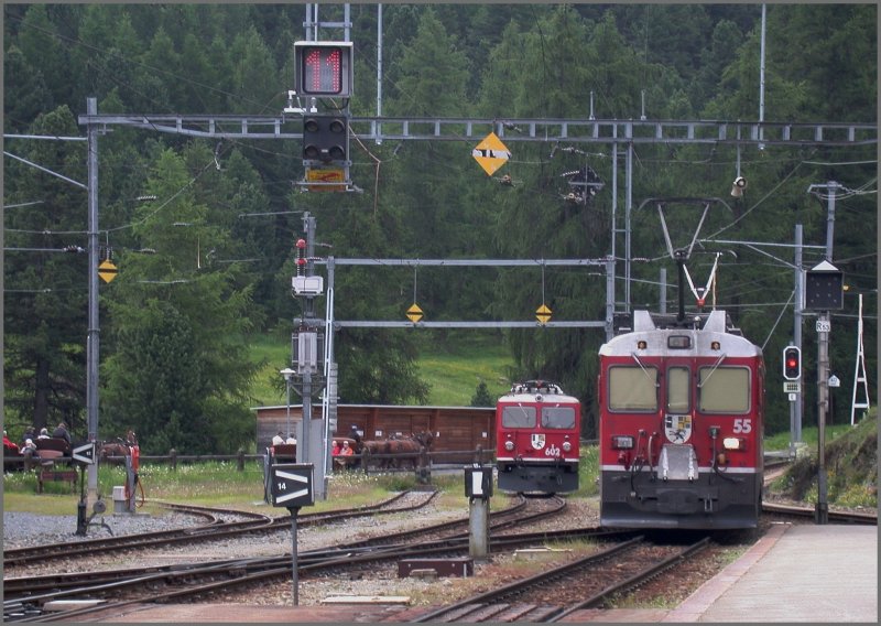 Am Ende von Gleis 3 in Pontresina warten die Gleichstromtriebwagen der Berninabahn auf die bernahme der Panoramawagen des Bernina Express. Gleis 3 ist umschaltbar zwischen 11`000 Volt Wechselstrom und 1000Volt Gleichstrom. Vor der Wegfahrt der Stammnetzlok zeigt das Signal noch die 11. Im Hintergrund abgestellt ist die Ge 4/4 I 602  Bernina . Dahinter bewegen sich zwei Pferdekutschen Richtung Val Roseg. (13.06.2007)