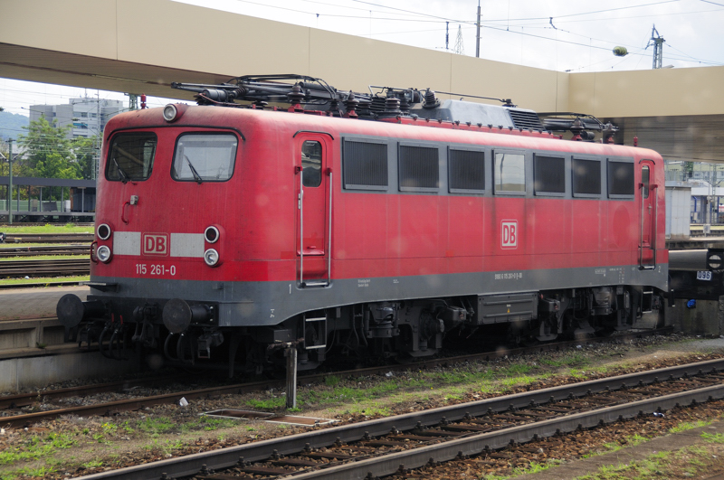 Am Stumpfgleis des Bahnsteigs 4/5 dste 115 261-0 in der noch scheinenden, aber schon fahlen Mittagssonne. (Basel Bad Bf, 10.08.09).