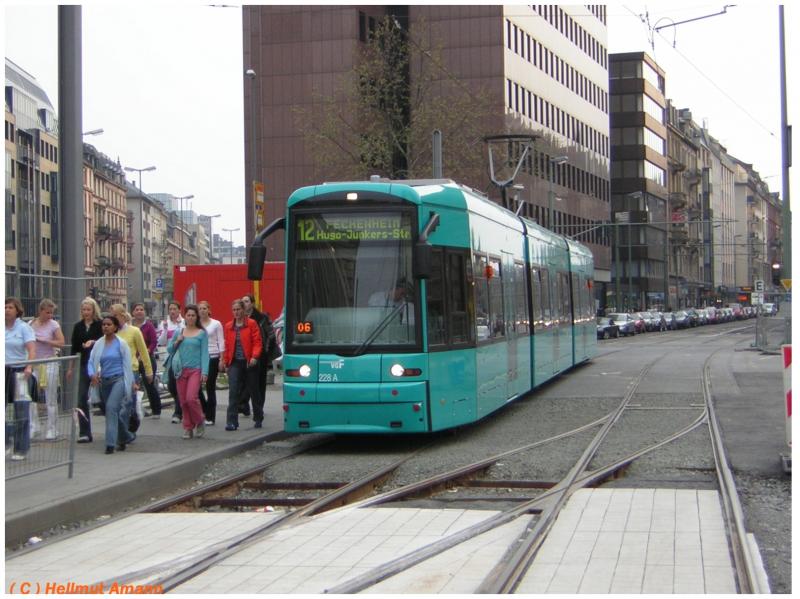 Am Willy-Brandt-Platz hielten die Stra�enbahnen w�hrend der Umbauma�nahmen an der Haltestelle am westlichen Ende des Bahnsteigs. Der S-Triebwagen 228 hatte am 16.04.2005 als 6. Zug der Linie 12 nach Fechenheim die T�ren schon wieder geschlossen, w�hrend die ausgestiegenen Fahrg�ste bereits ihren Zielen entgegeneilten. Am Gleiswechsel klaffte noch eine L�cke zwischen dem alten und dem neuen Pflaster zwischen den Gleisen.