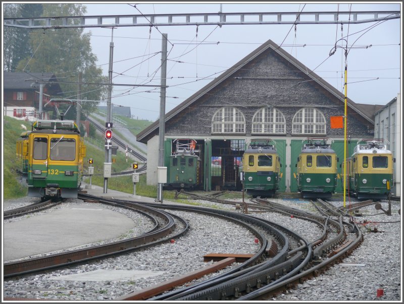 An einem nebligen Morgen vor dem Depot der WAB in Grindelwald Grund, dieses Mal mit ganzem Dach. Der BDhe 4/8 132 manveriert zum Umsetzen auf Gleis 1 Richtung das ansteigende Streckengeleise nach Grindelwald. Fr Arbeiten auf dem Dach des Oldtimers He 2/2 54 wurden die Depotgeleise ausgeschaltet und mit der hngenden Erdungsstange gesichert. (11.10.2007)