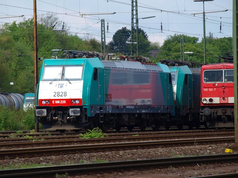 An einem sonnigen Aprilmorgen spiegelt sich die 155 102-7 in der blitzsauberen Belgischen 186 220 am Aachener Westbahnhof.