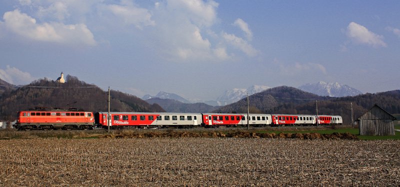 An einem wunderschnen Frhlingstag hielt ich es nicht mehr daheim aus und fuhr auf nach Micheldorf, wo nach lngerer Wartezeit die blutorange 1142.542 mit dem R 3972 nach Linz Hbf daherkam. Die Kirche und das Wartehaus mussten natrlich auch mit aufs Bild, und das folgende Foto kam heraus. 05.04.09