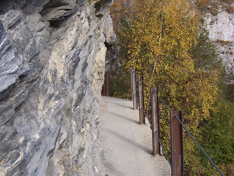 An einigen Stellen wurde der Hhenweg aus dem Fels gesprengt wie hier am Luogelkin-Viadukt, aufgenommen am 13.11.2006. Die BLS hat sich diesen schnen Weg einiges kosten lassen, Eisenbahnschienen sind auch als Baumaterial fr's Gelnder geeignet.