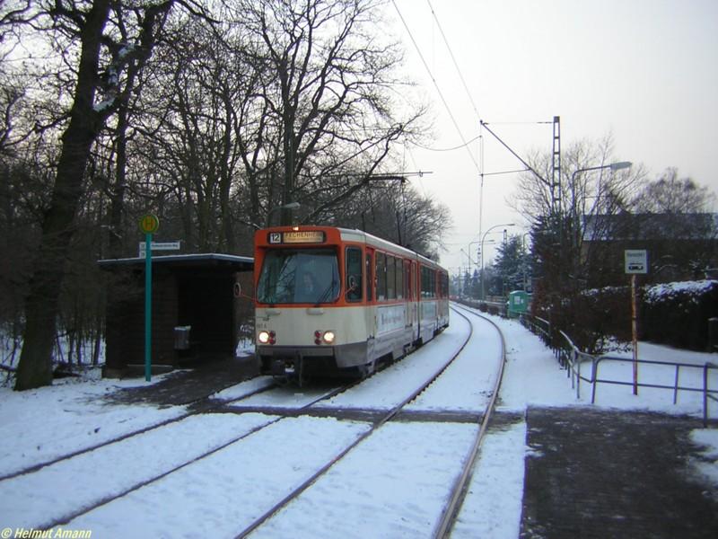 An der Haltestelle Ferdinand-Dirichs-Weg ist am Abend des 26.01.2006 gerade der 10. Zug der Linie 12 nach Fechenheim mit dem Pt-Triebwagen 681 in alter Farbgebung vorgefahren, der auf der
verschneiten Strecke am Waldrand erschwerte Bedingungen hat, um seinen Dienst zu leisten.