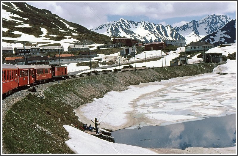 Anfangs Juni finden die fischenden Buben erst ein kleines Loch im Eis des Oberalpsees, whrend dem der Glacier Express in die Station rollt. Danach beginnt der steile Abstieg nach Disentis. (Archiv 06/77)