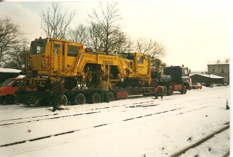 Ankunft einer Schmalspurgleisstopfmaschine im Dezember 1998 in Putbus auf einem Schwerlasttransporter.