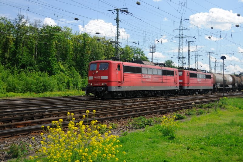 Auch wenn es viele satthaben... die rote Lackierung der DB-Loks kann auch zu einem richtigen Farbklecks im satten Grn werden: 151 082-5 und 151 151-8 mhen sich vor einem schweren KeWa-Ganzzug in Gremberg Richtung Kln-Kalk. (19.05.2009).