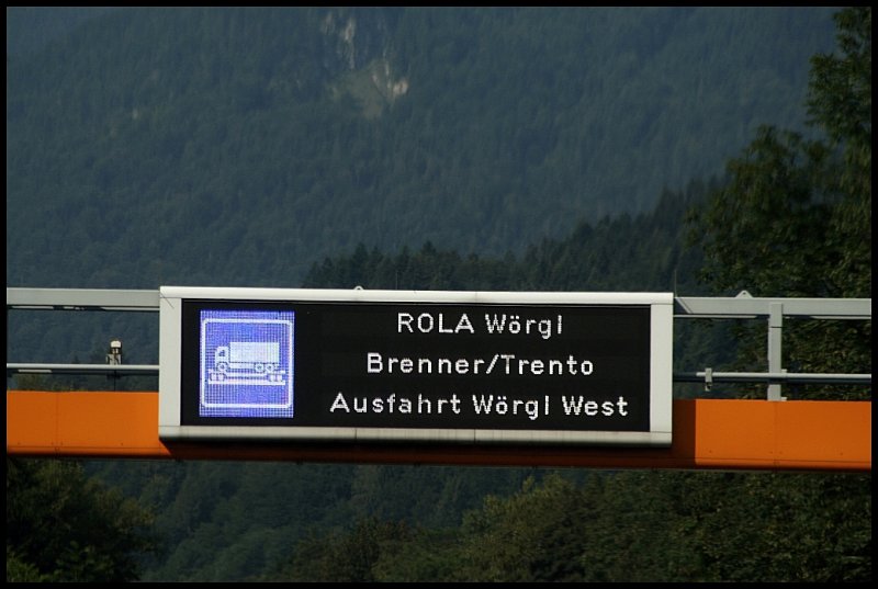 Auf der A13  Inntalautobahn  zwischen Kiefersfelden und Kufstein weisen diese Schilderbrcke mit LED-Hinweistafel und normale Hinweistafeln am Rande der Fahrbahn auf die RoLa hin. Auf der Tafel steht  ROLA Wrgl Brenner/Trento Ausfahrt Wrgl-West .