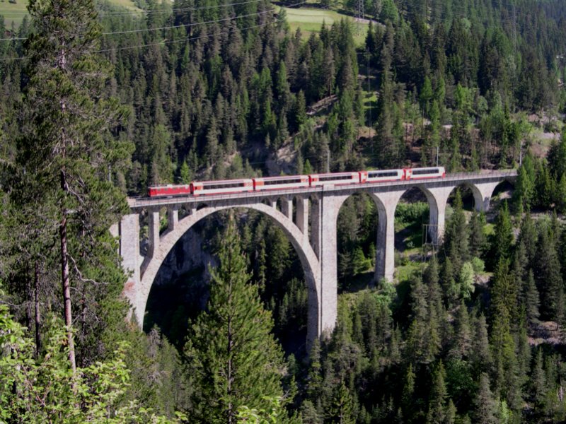 Auf dem gretn bauwerk der Strecke Davos-Filisur, dem Wiesener Viadukt, ist am 15.06.2006 D 909  Glacier-Express  Davos - Filisur - Chur - Disentis - Andermatt - Brig - Zermatt unterwegs. Seit Dezember 2005 wird dieser Zug nicht mehr via Klosters nach Chur gefhrt, sondern befhrt ab Filisur die Albulabahn. Dafr ist in Filisur ein Lokwechsel notwendig. Fr diese Arbeit hlt die RhB sogar Rangierpersonal in Filisur vor.