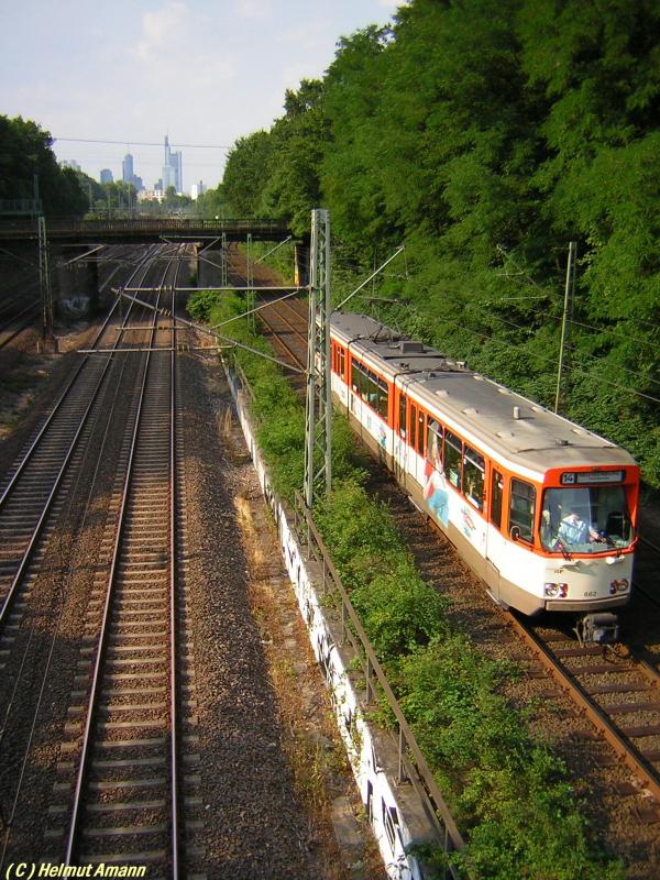 Auf der Fahrt nach Neu-Isenburg f�hrt die Stra�enbahnlinie 14 bei
Frankfurt am Main - Louisa ein kurzes St�ck parallel zu der Strecke der DB. Das Gl�ck, eine Parallelfahrt zweier Z�ge auf 
das Bild zu bekommen, ist dem Fotografen hier leider selten hold, obwohl sich an dem Fotopunkt drei Strecken kreuzen, wie an der Br�cke �ber die Trassen zu erkennen ist. Die Aufnahme vom 14.07.2005 zeigt den Pt-Triebwagen 662 auf dem 4. Zug der Linie 
14 in Fahrtrichtung Neu-Isenburg.