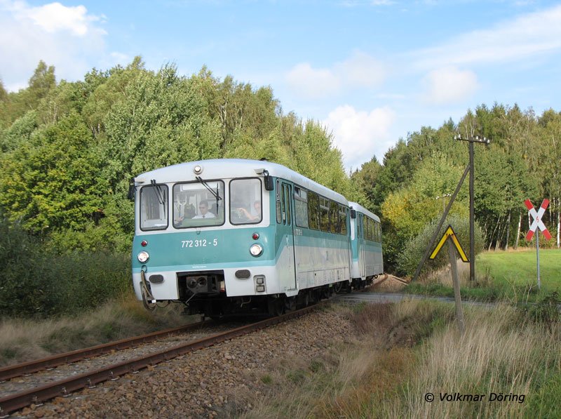 Auf der Fahrt von Nossen nach Freiberg passieren die Ferkeltaxen 772 312 + 772 367 der Vorwohle - Emmerthaler Verkehrsbetriebe (VEV) den Bahnbergang bei km 9,4 zwischen Zellwald und Grovoigtsberg  - 01.10.2006
