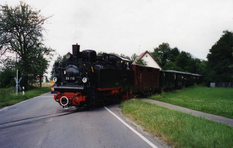 Auf der Museumsbahn  chsle  kann man an Sonntagen Fahrbetrieb erleben, so wie im Juli 1997. Diese Aufnahme entstand kurz vor Warthausen als gerade die 99 716 mit ihrem Personenzug von Ochsenhausen eine Strae kreuzt.
