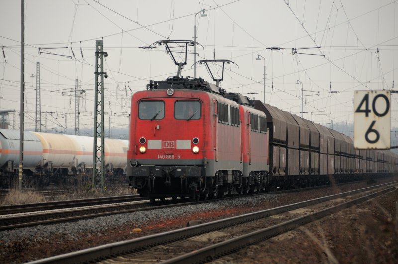 Aufgenommen an der KBS 651 Darmstadt-Aschaffenburg: 140 866-5 und Schwesterlok mit einem Schttgutwagen-Ganzzug. Als hlt jemand wie in der Formel 1 eine Gridkarte in die Strecke. (10.03.09) 