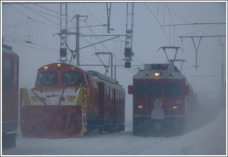 Aus dem Schneesturm taucht fast lautlos ein Gterzug nach Poschiavo auf, gezogen von ABe 4/4 III 54 und Gem 802  Murmeltier . (17.02.2009)