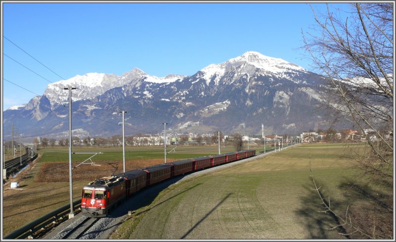 Aus Richtung Igis nhert sich ein RE nach Disentis/Mustr mit der Ge 4/4 II 628  S-chanf  an der Spitze. Links die SBB Doppelspur nach Landquart, das sich beim Hochhaus im Hintergrund befindet. (27.12.2007)