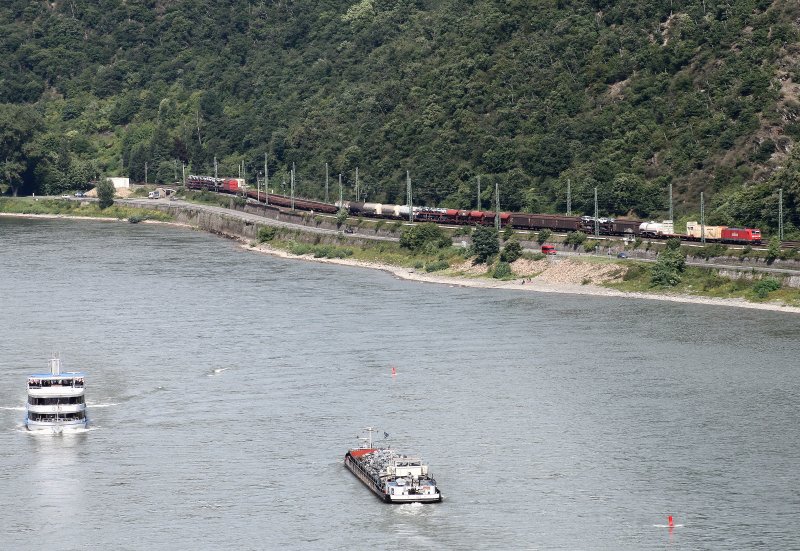 Aus den Weinbergen der Stadt Oberwesel hat man einen weiten Blick. So auch auf die linke Rheinstrecke, die zur Nachmittagszeit des 14. August 2008 gerade von einer Baureihe 185 mit einem gemischten Gterzug in Richtung Wiesbaden befahren wird. Zeitgleich begegnen sich auf dem Rhein ein Touristenschiff und ein Frachtschiff.
