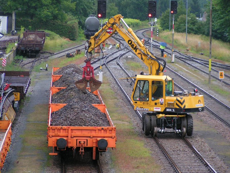 Bagger auf Schienen beldt Arbeitswagen mit Abraumgut; Bhf. RIED i.I. 2006-08-12