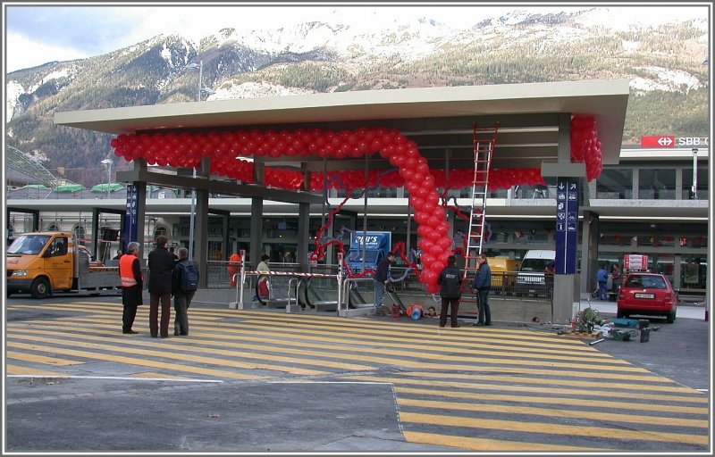 Bahnhof Chur Neues Tor zur Stadt Erffnung 08.12.2006 12.00Uhr.
Bis zur letzten Minute wird noch montiert, geteert, gemalt und gereinigt, damit der neue Aufgang aus der Bahnhofunterfhrung zur Stadt termingerecht erffnet werden kann. Der wohl grsste Fussgngerstreifen der Stadt Chur leitet die Passanten direkt zu den neuen Geschften im Untergrund und nicht zuletzt auch zu den Zgen. Die Ballonbefestiger kmpfen gegen den heftigen Fhnsturm.