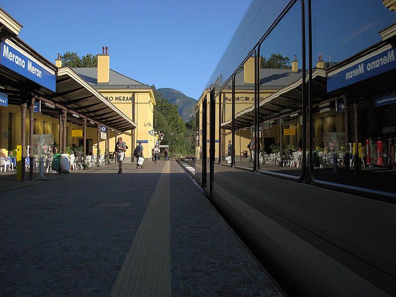 Bahnhof Meran mit Spiegelung im ATR 100 003 der Vinschgerbahn, 06. Sept. 2009, 17:59