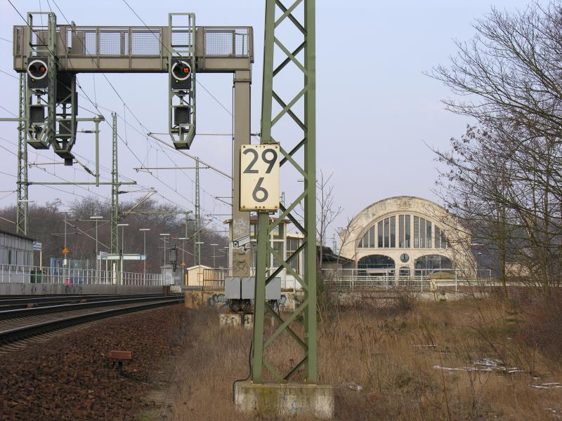 Bahnhof Potsdam Park Sanssouci, fr�her Wildpark, Signalausleger f�r Vorsignalwiederholer, im Hintergrund der wieder aufgebaute Kaiserbahnhof, Nutzung durch die DB als Schulungszentrum f�r Manager. 2 historische Wagen stehen seit 2/2005 bereits in der Halle. Sie sind in Noppenfolie verpackt (Baustaub).