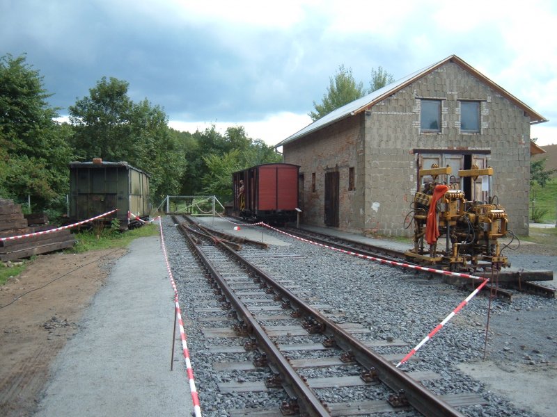 Bahnhofsfest in Lohsdorf am 20.08.2006. Der sdliche Teil der Gleisanlage hinter der nur teilweise abgerissenen LPG-Halle. Zu sehen ist hier auch der Gterschuppen. Im rechten Bereich vor der Gleisstopfmaschine ist seit kurzem auch die zweite Weiche vorhanden. Jetzt knnen die Freunde der Schwarzbachbahn auch ein  N  oder  Z  befahren. Bemerkenswerte Arbeit! Gott sei dank wurde die Strecke offiziell nie stillgelegt - ist ein riesen Vorteil fr den Wideraufbau. 