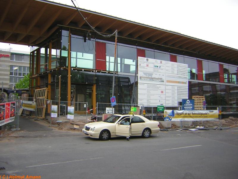 Bahnhofsvorplatz Rsselsheim am 02.07.2005, die Fensterfront am Ostflgel des noch im Bau befindlichen neuen Bahnhofsgebudes war
bereits fertiggestellt.