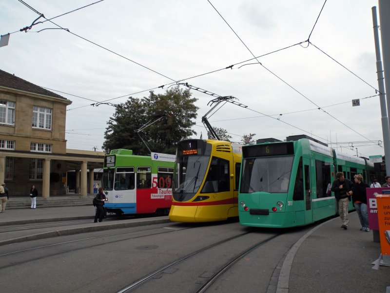 Basel hat doch farbenfrohe Tramzge! Grner Combino 311, Gelbroter Tango 153 und das Werbetram der reformierten Kirche Be 4/6 S 671 am Badischen Bahnhof. Die Aufnahme entstand am 15. September 2009.