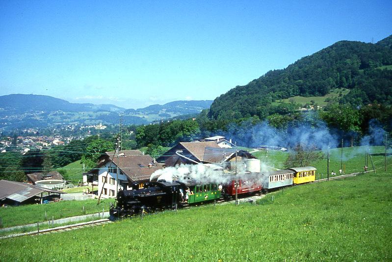 BC Museumsbahn DAMPFZUG 327 von Vevey nach Weiche -(Chaulin) am 24.05.1999 bei Cornaux mit Zahnrad-Dampflok exBFD HG 3/4 3 - exCEG C 23 - exCEV BC21 - ex MOB C4 45 - exRhB As 2.
