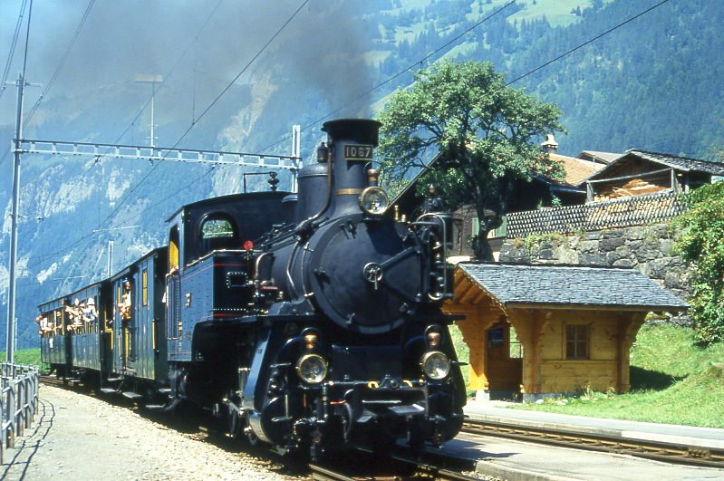 BDB Ballenberg Dampfbahn Dampfzug 2255D von Interlaken Ost nach Grindelwald am 06.08.1994 in Burglauenen mit Zahnrad-Dampflok HG 3/3 1067 - F 51 - BC 28 - C 31. Hinweis: gescanntes Dia.
