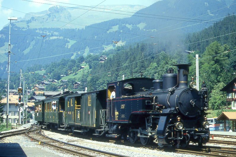 BDB Ballenberg Dampfbahn Dampfzug 2255D von Interlaken Ost nach Grindelwald am 06.08.1994 Einfahrt Grindelwald mit Zahnrad-Dampflok HG 3/3 1067 - F 51 - BC 28 - C 31. Hinweis: gescanntes Dia.
