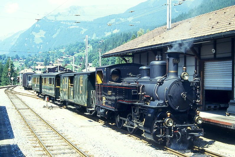 BDB Ballenberg Dampfbahn Dampfzug 2255D von Interlaken Ost nach Grindelwald am 06.08.1994 Einfahrt Grindelwald mit Zahnrad-Dampflok HG 3/3 1067 - F 51 - BC 28 - C 31. Hinweis: gescanntes Dia.
