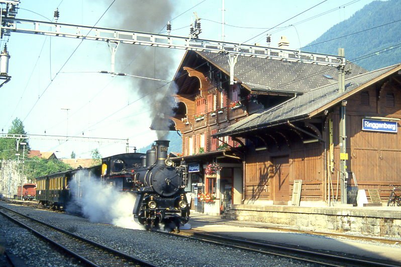 BDB Ballenberg Dampfbahn Dampfzug 32021 von Interlaken Ost nach Brienz am 06.08.1994 Durchfahrt Ringgenberg mit Zahnrad-Dampflok HG 3/3 1067 - F 51 - BC 28 - C 31. Hinweis: gescanntes Dia.
