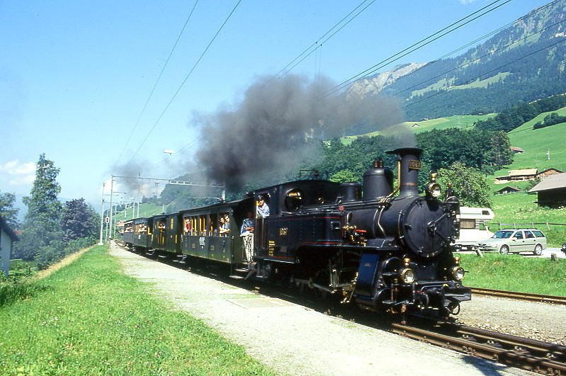 BDB Ballenberg Dampfbahn Dampfzug 32022 von Giswil nach Interlaken Ost am 10.08.1997 Einfahrt Lungern mit Zahnrad-Dampflok HG 3/3 1067 -  C 31 - F 51 - BC 28 - C 41. Hinweis: gescanntes Dia.
